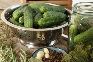 Fresh cucumbers, dill and spices on wooden table, closeup. Preparation for pickling