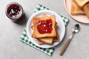 Delicious toasts with jam on light table, flat lay