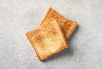 Slices of delicious toasted bread on light table, top view