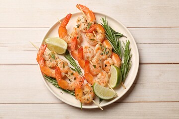 Skewers with delicious grilled shrimps served on white wooden table, top view
