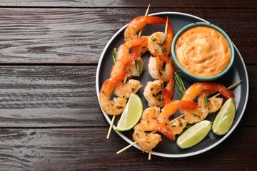 Skewers with delicious grilled shrimps served on wooden table, top view. Space for text
