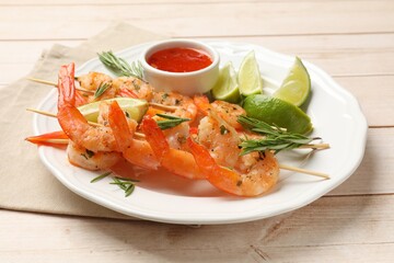 Skewers with delicious grilled shrimps served on wooden table
