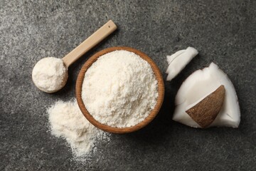 Organic coconut flour in bowl, spoon and fruit pieces on grey table, flat lay