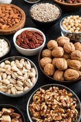 Fototapeta premium Raw walnuts and cashew with almonds and peanuts with organic nuts and seed in various assorted bowls.Macro