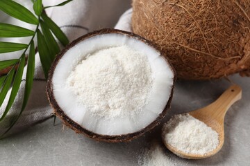 Organic coconut flour, fresh fruit and leaf on light grey table, closeup