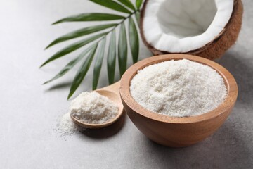 Organic coconut flour, fresh fruit and leaf on light grey table, closeup