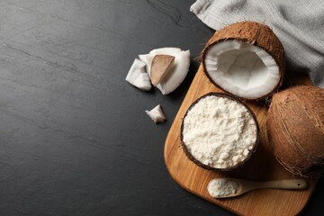 Organic coconut flour and fresh fruits on black table, flat lay. Space for text