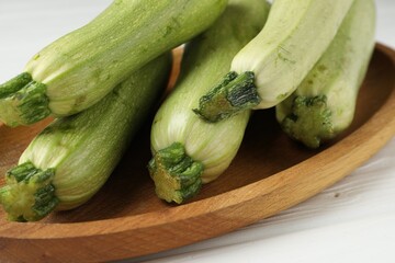 Raw green zucchinis on white wooden table, closeup