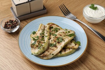 Tasty grilled courgette slices served on wooden table