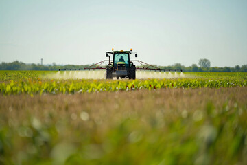 Obraz premium Modern Tractor Spraying Agricultural Field for Efficient Crop Protection and Growth