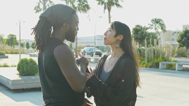 Sunset paints the sky as an Asian and African American couple dance by a pier, their movements blending gracefully with the evening&rsquo;s warm colors, celebrating connection and harmony.