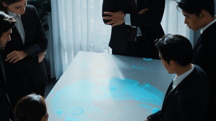 Top view of project manager looking hologram of global networking connection table surrounded by diverse business people brainstorm and planning strategy by using digital communication. Directorate.