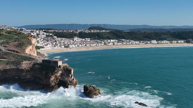 Lighthouse in Nazare, Portugal. Famous place for waves and surfing. Beach and Ocean Waves in Background. 4k