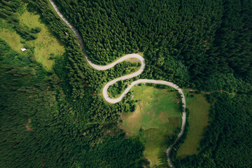 Aerial view of the road passing through the mountain and green forest. Curve asphalt road on mountain.	
