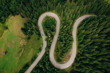 Aerial view of the road passing through the mountain and green forest. Curve asphalt road on mountain.	
