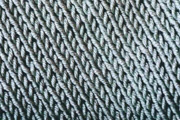 A close up of a knitted fabric with a pattern of white and gray