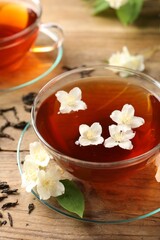 Hot jasmine tea in cups and flowers on wooden table