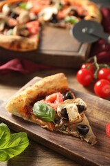 Piece of tasty pizza with basil, mushroom, olive and tomato on wooden table, closeup