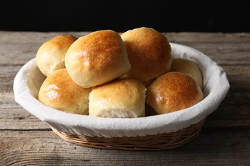 Delicious dough balls in basket on wooden table