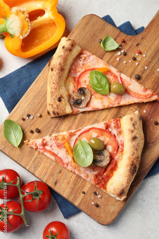 Wall mural Cut delicious vegetarian pizza and ingredients on light grey table, top view