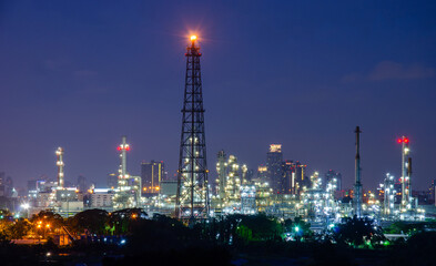 Fototapeta premium Chimney Oil refinery plant from industry zone, Aerial view oil and gas petrochemical industrial, Refinery factory oil storage tank and pipeline steel at night