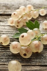 Fresh white currant berries and green leaf on wooden table, closeup