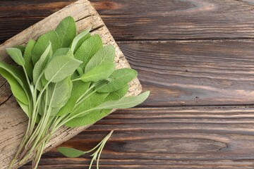 Obraz premium Green sage leaves on wooden table, top view. Space for text
