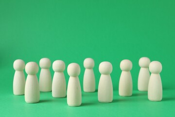 Group of wooden human figures on green background