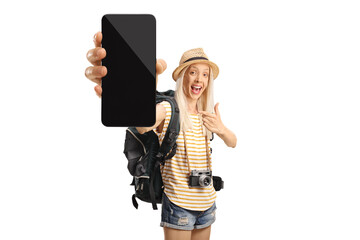 Happy female tourist with a backpack pointing at a smartphone