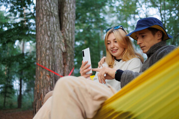 Hammock Bliss: Couple Engrossed in Phone