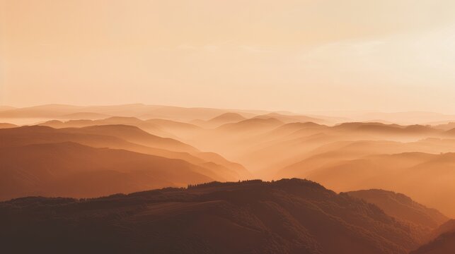A breathtaking view of a mountain range bathed in the warm glow of the setting sun, with layers of mountains and fog creating a sense of depth and serenity. The image embodies tranquility, natural bea