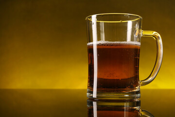 Glass of beer with froth on dark table, closeup