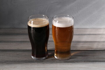 Glasses with different types of beer on grey wooden table