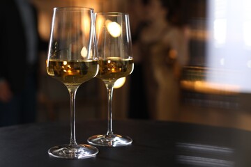 Different tasty wines in glasses on black table indoors, selective focus