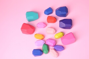 Many colorful balancing stones on pink background, top view