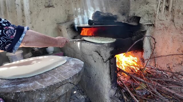 preparing bread in a traditional Dagestan village bakery. Bread is a flatbread baked in a Koryuk oven, common in the cuisine of the North Caucasus.