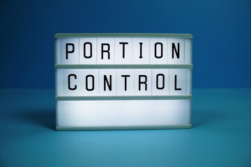 Portion Control letterboard text on LED Lightbox on blue background, Healthcare concept background