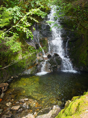 Rainbow Falls waterfall about ten miles from Ketchikan, Alaska, plunges into a clear shallow pool amid large boulders