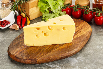 Swiss Maasdam cheese triangle over board