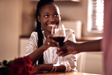 Black people, couple and flowers with wine glass for toast for love, support and valentines day. Home, relationship and smile with roses as gift or present for romance or anniversary celebration