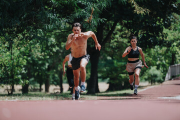 Group of athletes running on a track in a park. Focused individuals competing in an outdoor sprint during a sunny day.