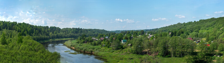 Panoramic view of the serene river surrounded by lush vegetation, on the shore of the village