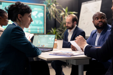 Fototapeta premium Team of business associates debating ways to increase profit in a decisional conference, analyzing sales info to conclude project. Enterprise colleagues joining forces to accomplish objectives.