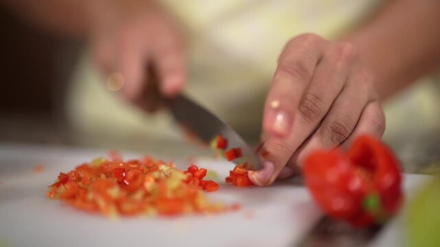 Manos de mujer cortando aj&iacute; de colores para preparar comida del hogar en c&aacute;mara lenta