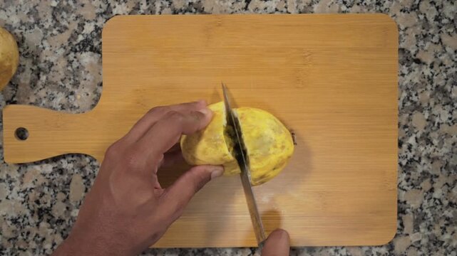 Manos con cuchillo cortando fruta de maracuy&aacute; por la mitad para hacer jugo delicioso en c&aacute;mara lenta