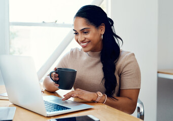 Woman, happy and coffee or laptop at desk for research, email or online review in morning. Journalist, technology and smile or writing article and internet for creativity, career or blog for company