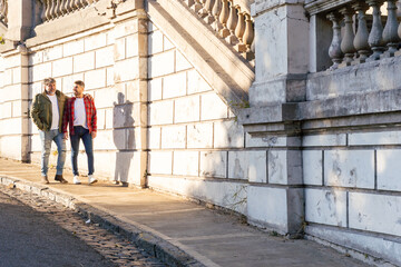 Two affectionate gay men walking on the street. Copy space