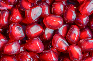 Macrophotography of several red pomegranate berries seen from the top