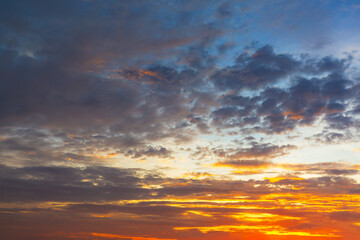 Fototapeta premium Beautiful Vivid sky painted by the sun leaving bright golden shades.Dense clouds in twilight sky in winter evening.Image of cloud sky on evening time.Evening Vivid sky with clouds