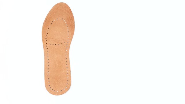 Leather orthopedic shoe insoles on a white background. Manufacturing of comfortable insoles for shoes, boots